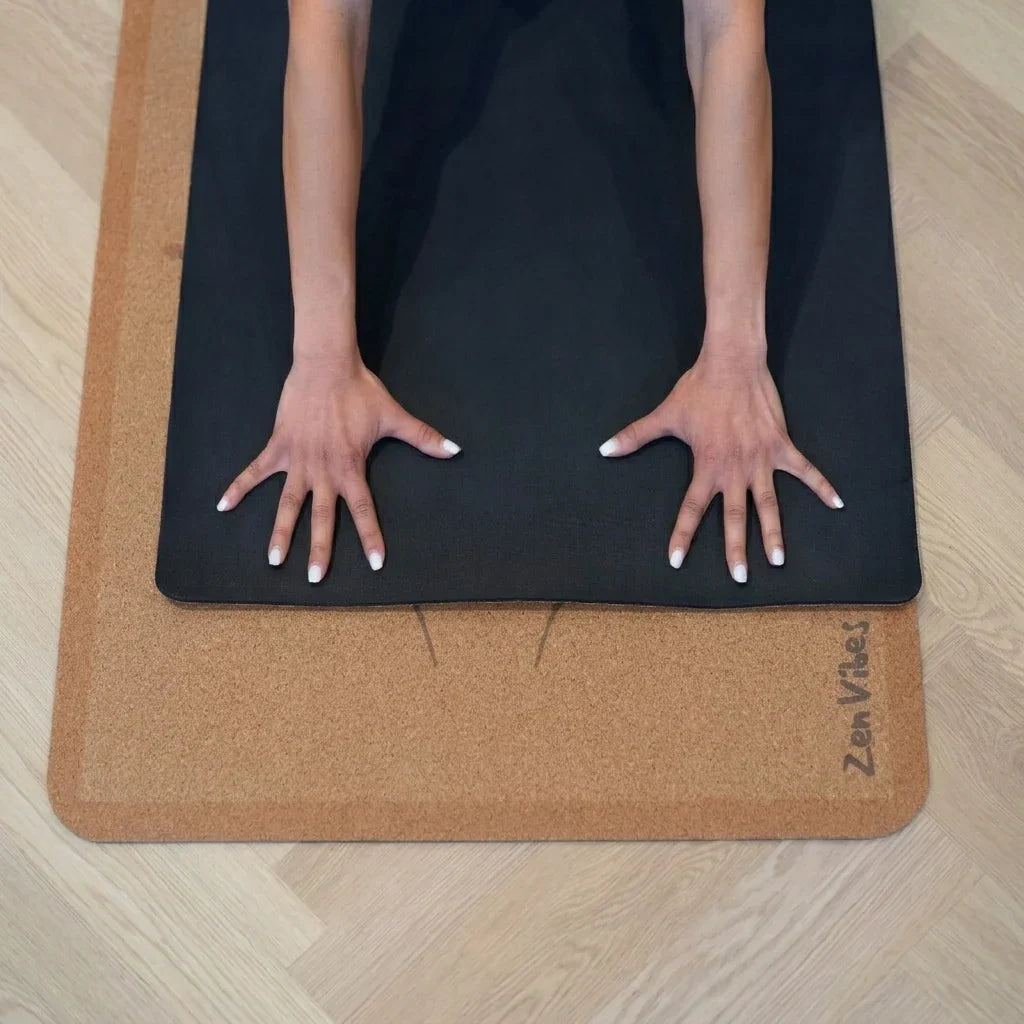 Close-up of hands on a Zenvibes extra wide black and cork yoga mat