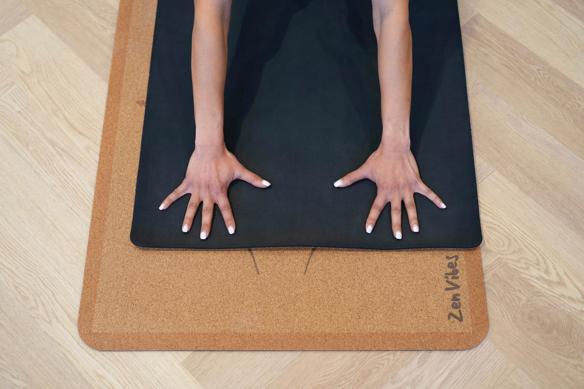 Hands of a person on a Zenvibes Hamsa Harmony extra wide cork yoga mat.