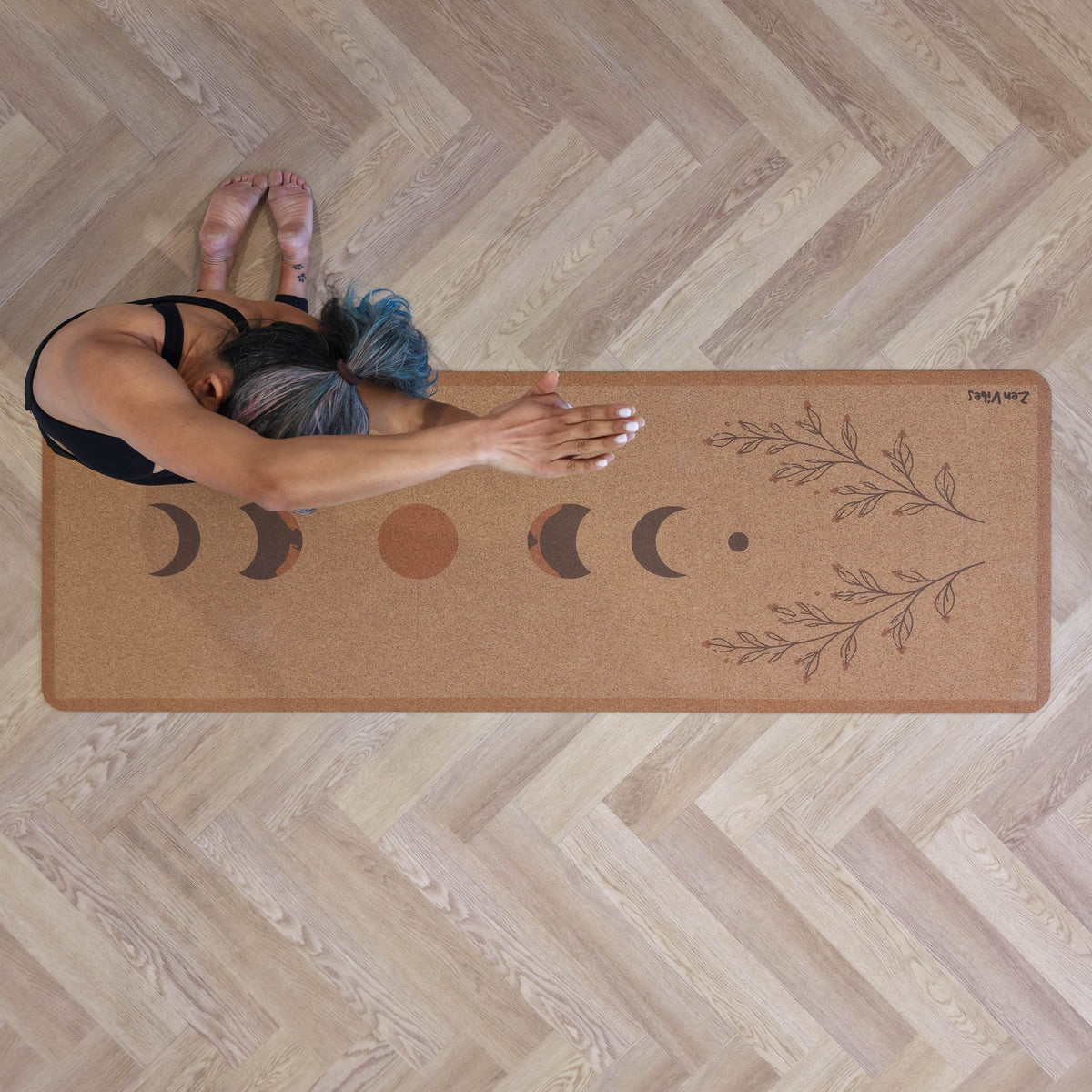 Woman stretching on a Zenvibes extra wide cork yoga mat with moon phase and leaf designs