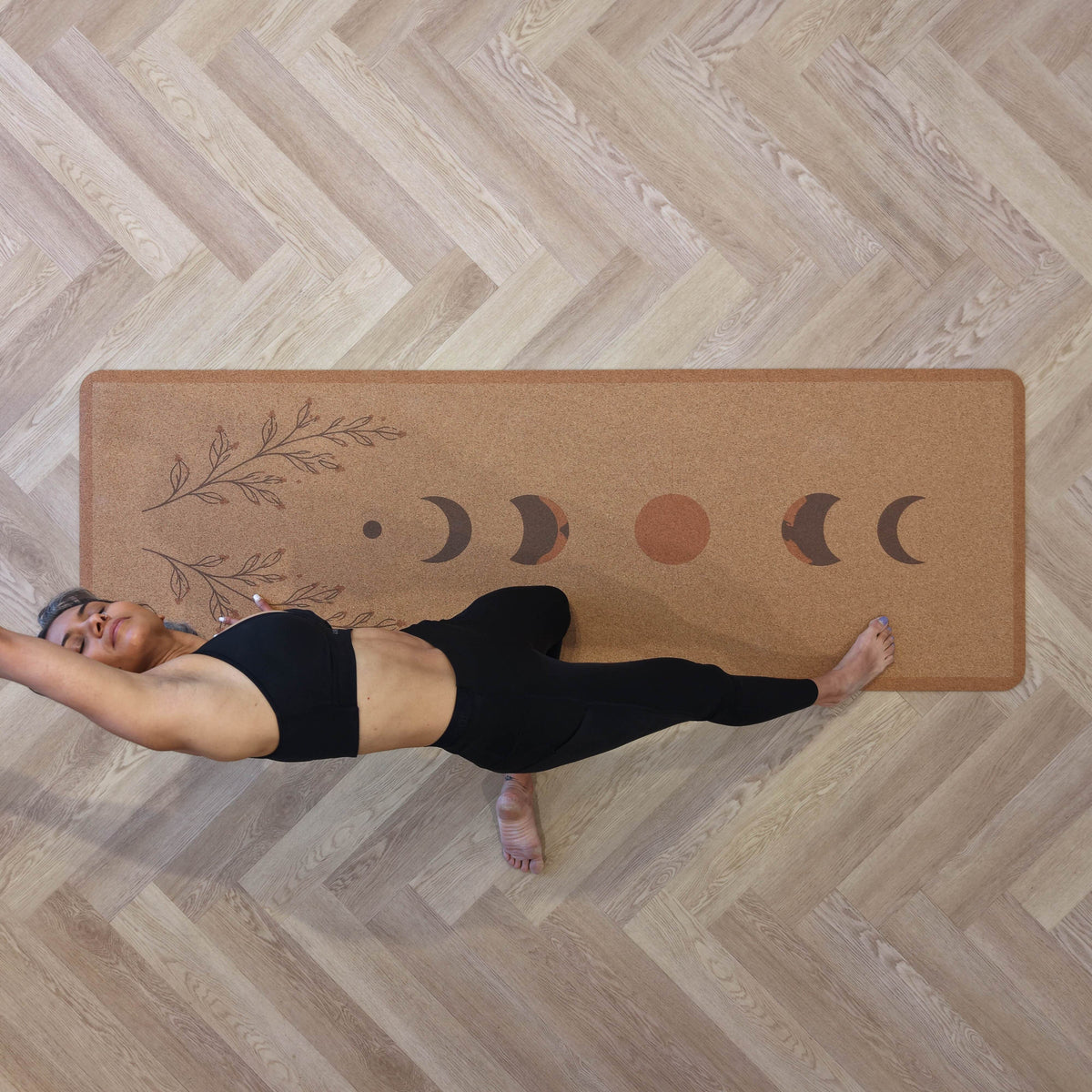 Woman practicing yoga on a Zenvibes extra wide cork yoga mat with moon phase design